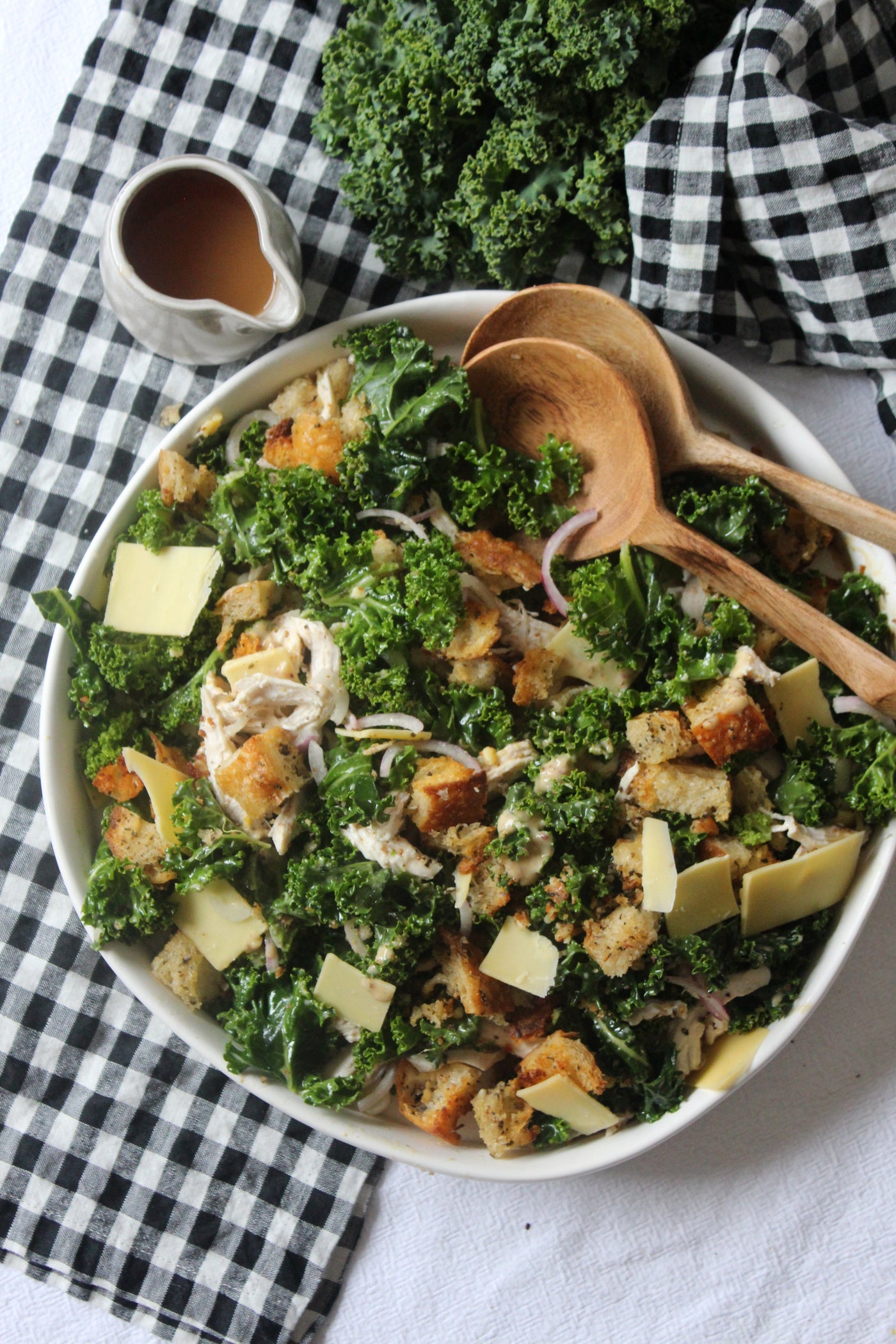 A big bowl of chicken and kale salad on a gingham napkin